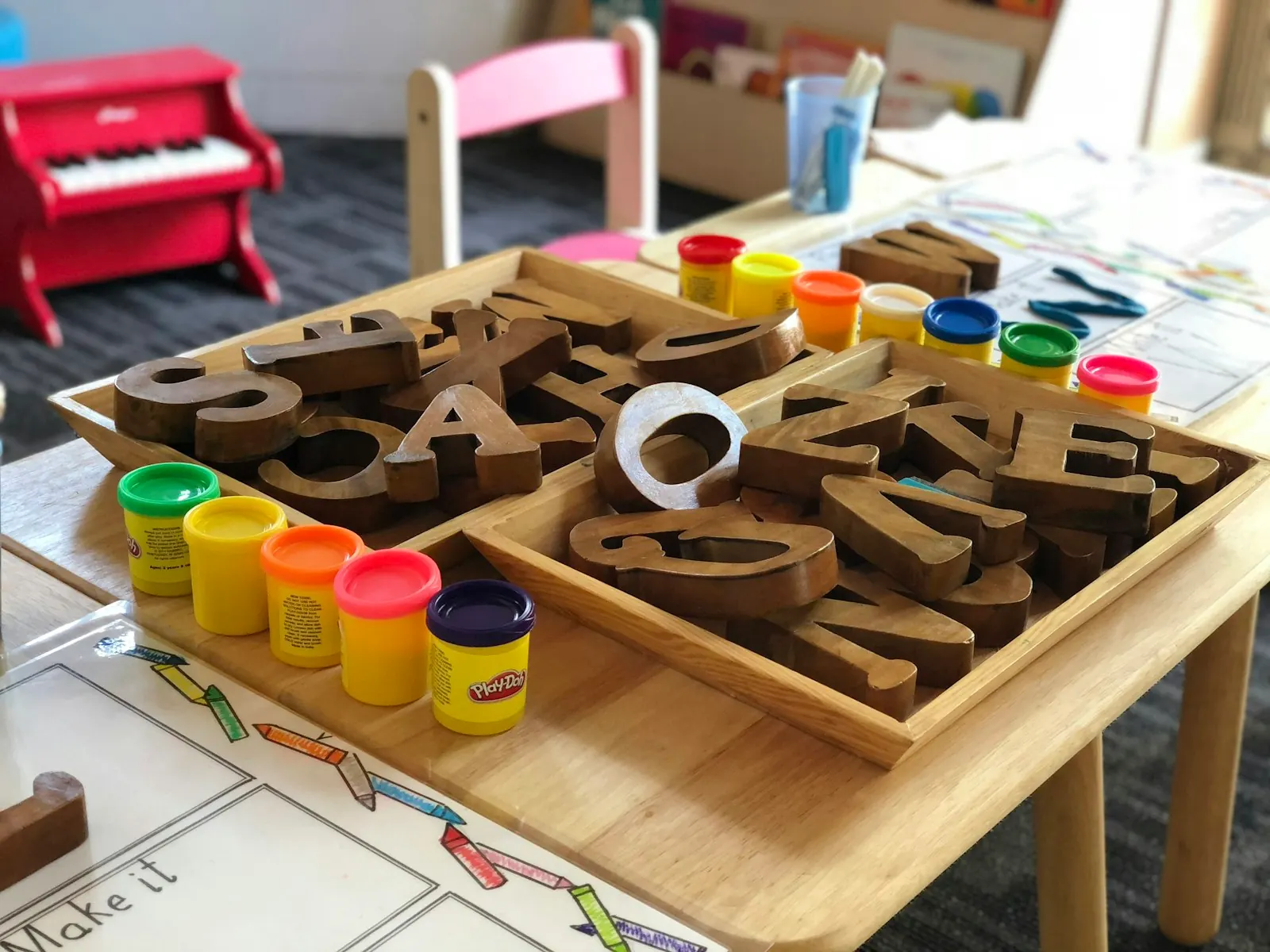 Wooden letter blocks and play dough on a learning table