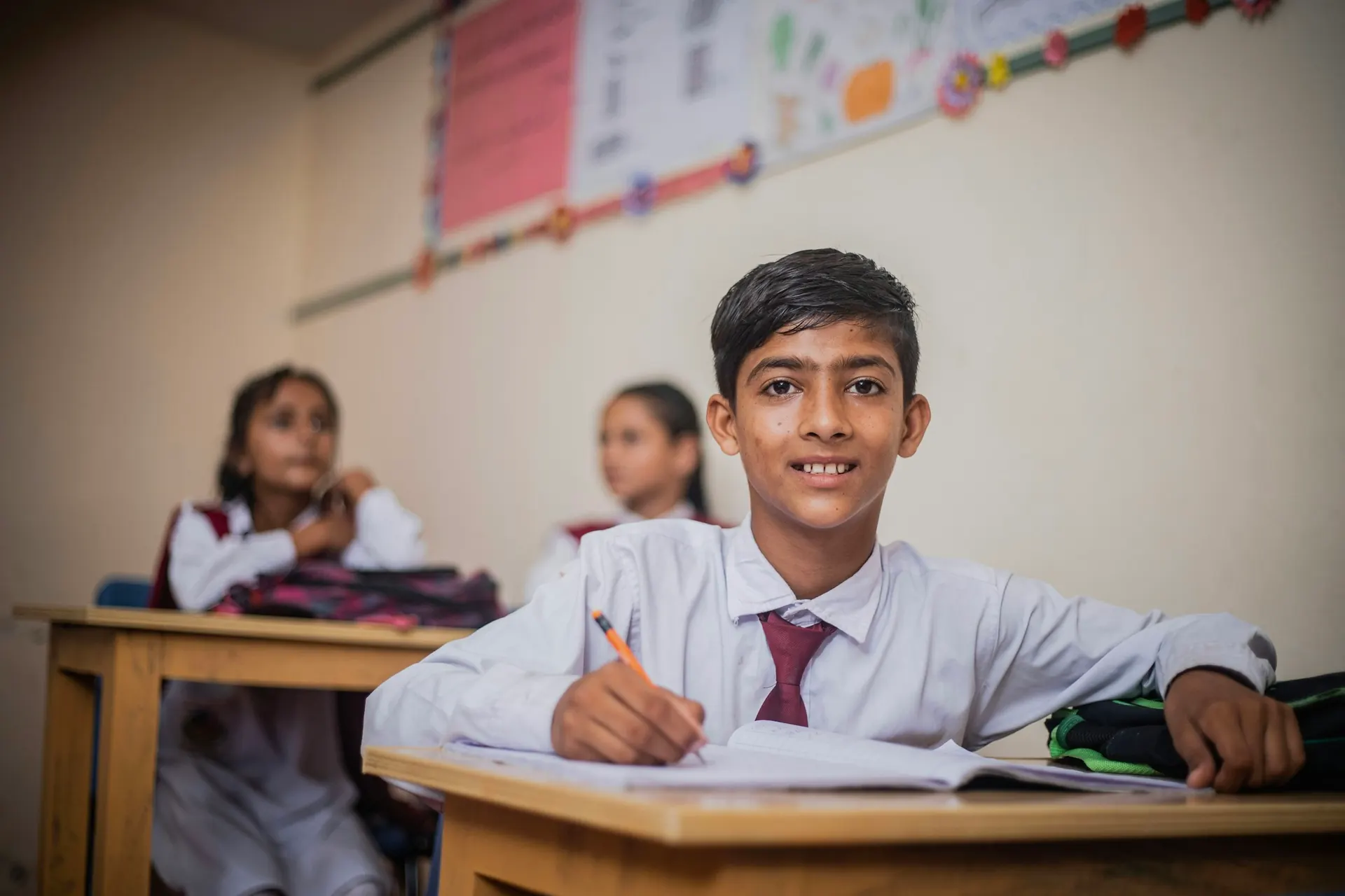 Student in uniform writing in his notebook