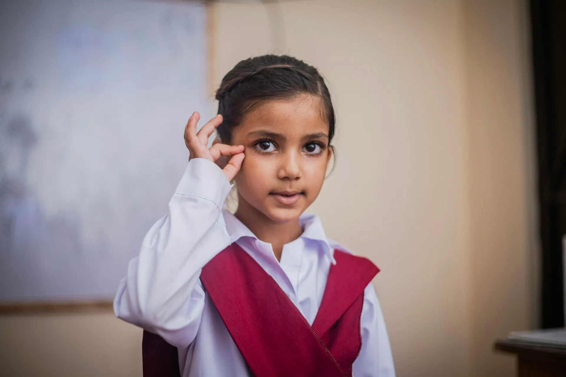 Young girl in school uniform smiling in class