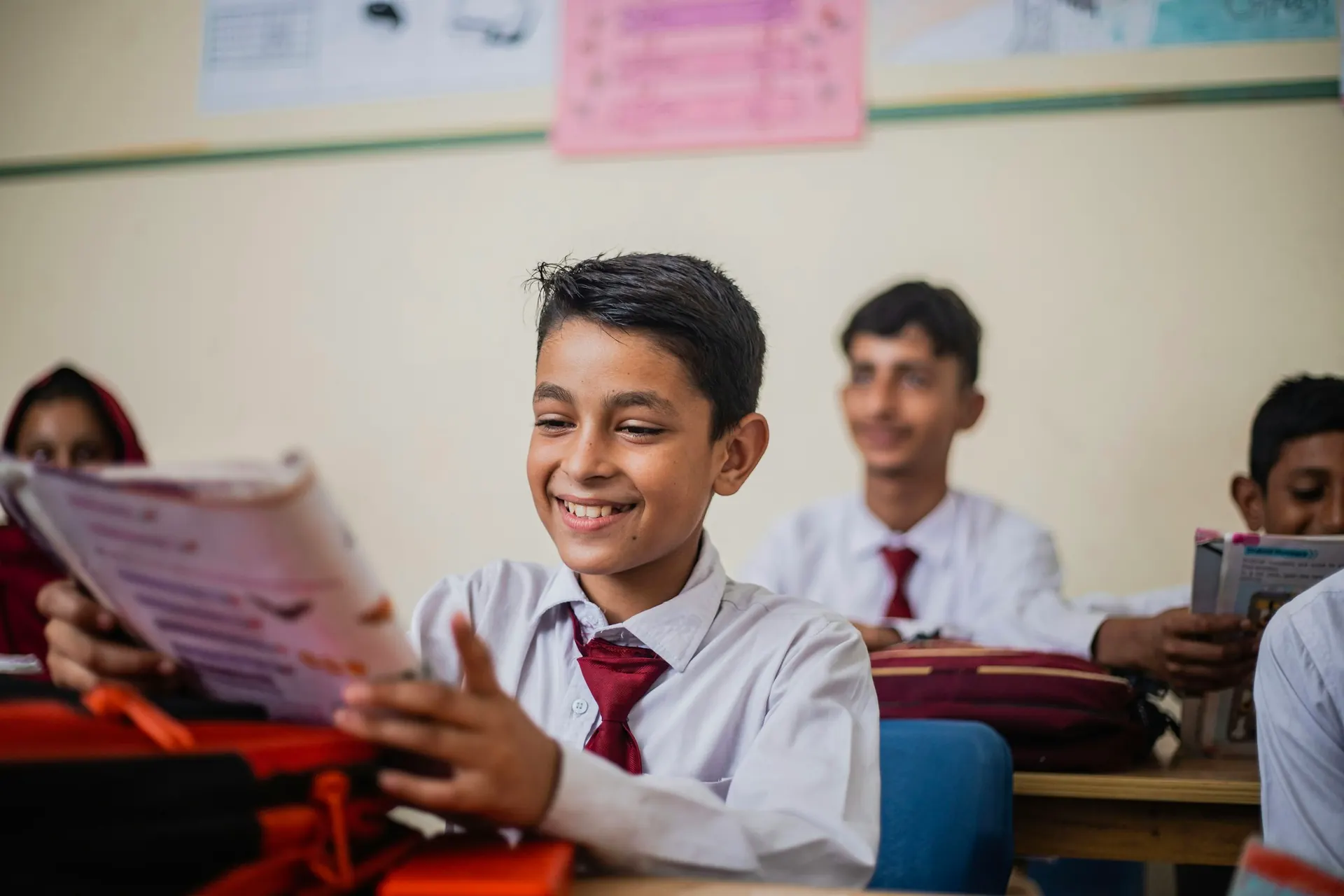 Smiling secondary student holding a textbook
