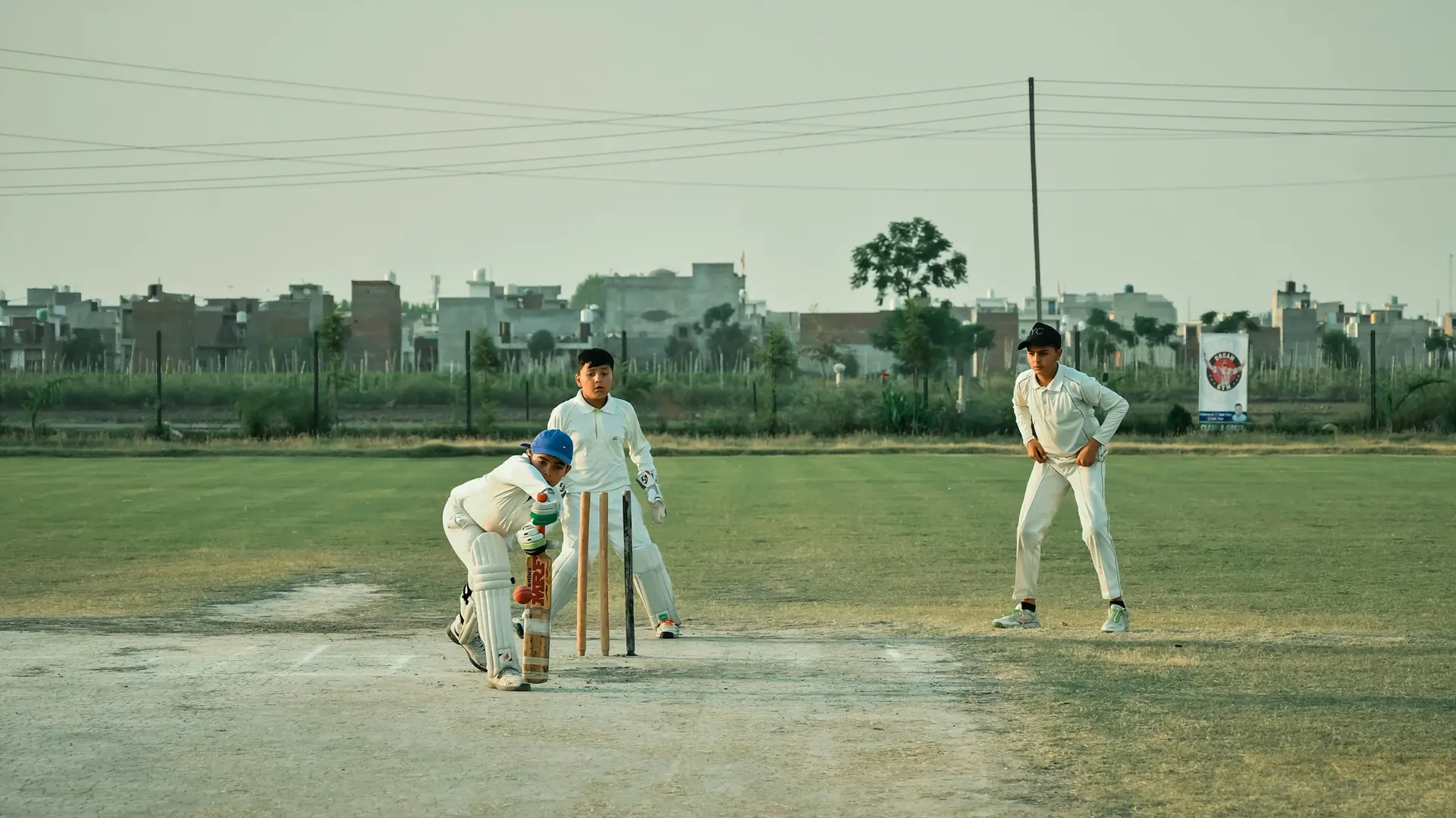 Students playing cricket on the school ground